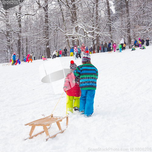 Image of Winter fun, snow, children sledding at winter time.