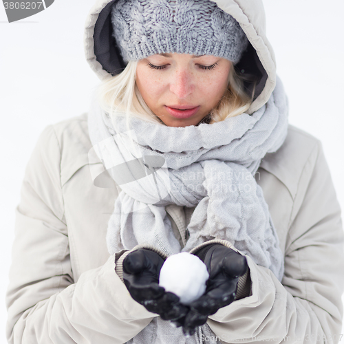 Image of Girl  holding snowball in cold winter time.
