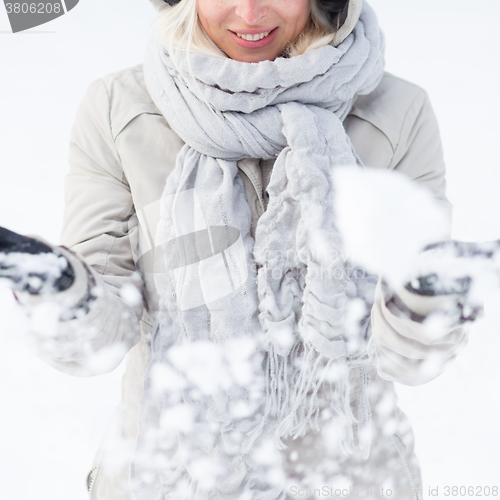 Image of Girl  playing with snow in winter.