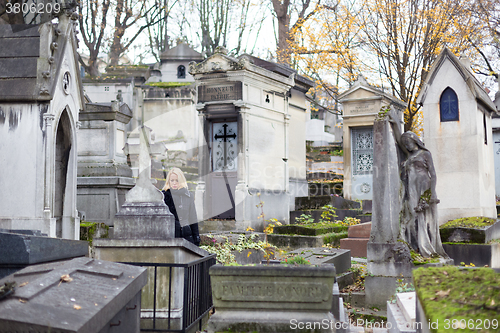 Image of Solitary woman visiting relatives grave.