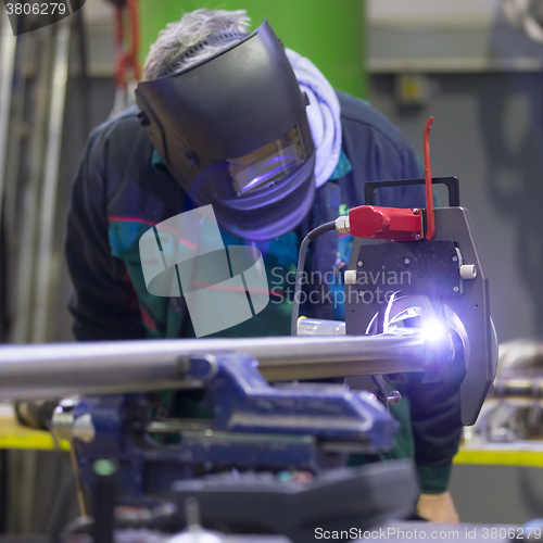 Image of Industrial worker setting orbital welding machine.