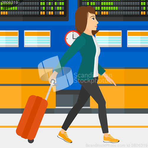 Image of Woman walking with suitcase.