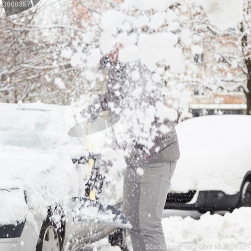 Image of Man shoveling snow in winter.