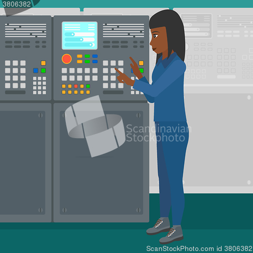 Image of Engineer standing near control panel.