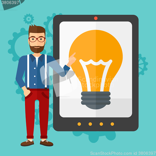 Image of Man pointing at tablet computer with light bulb on screen.