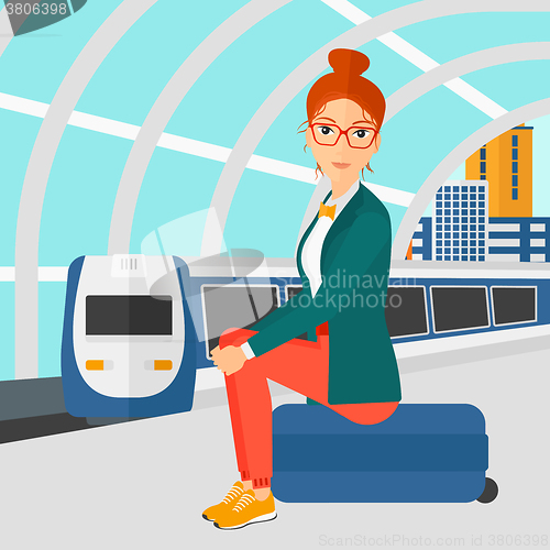 Image of Woman sitting on railway platform.