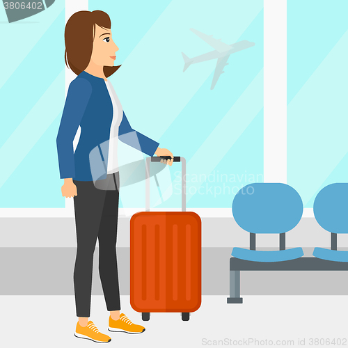 Image of Woman at airport with suitcase.