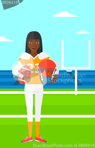 Image of Rugby player with ball and helmet in hands.