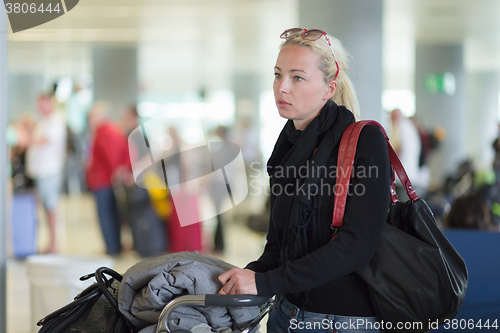 Image of Female traveler using cell phone while waiting.