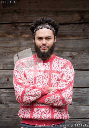 Image of portrait of young hipster in front of wooden house