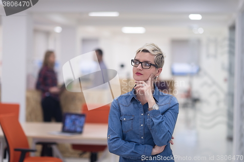 Image of portrait of young business woman at office with team in backgrou