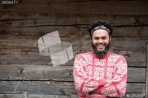 Image of portrait of young hipster in front of wooden house