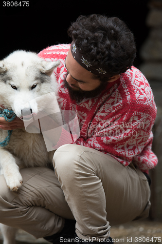 Image of hipster with dog in front of wooden house