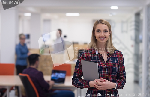 Image of portrait of young business woman at office with team in backgrou