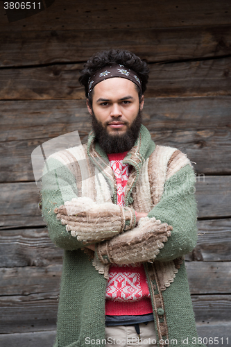 Image of portrait of young hipster in front of wooden house