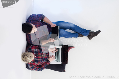 Image of top view of  couple working on laptop computer at startup office