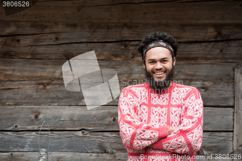 Image of portrait of young hipster in front of wooden house