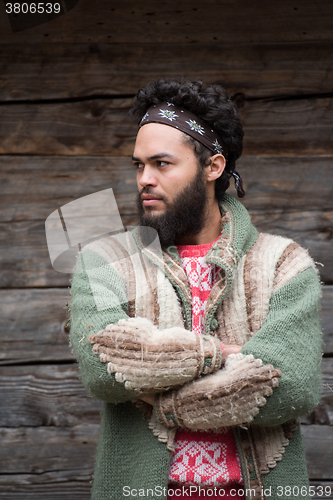 Image of portrait of young hipster in front of wooden house