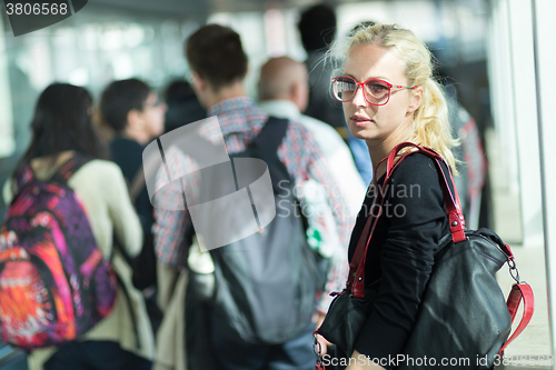 Image of Young blond caucsian woman waiting in line.