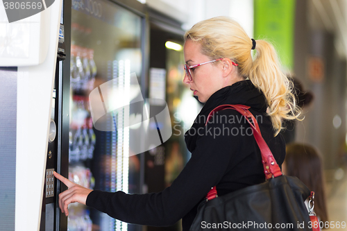 Image of Lady using  a modern vending machine