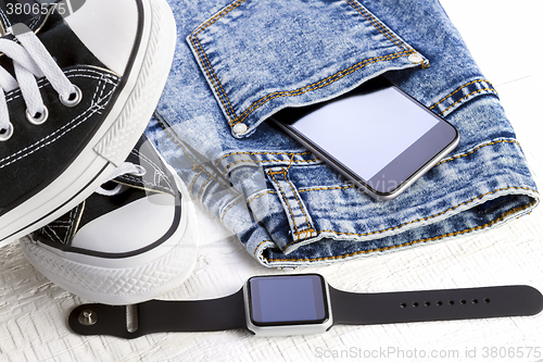 Image of jeans and fashion accessories on white wooden