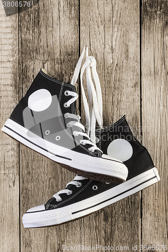 Image of Black sneakers on wooden
