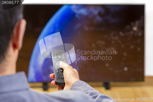 Image of Man sitting on a sofa watching tv 