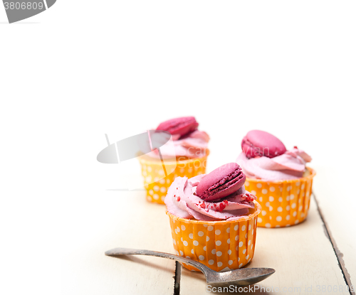Image of pink berry cream cupcake with macaroon on top