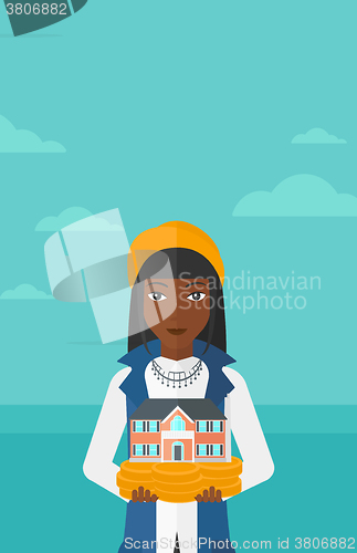 Image of Woman holding house model.