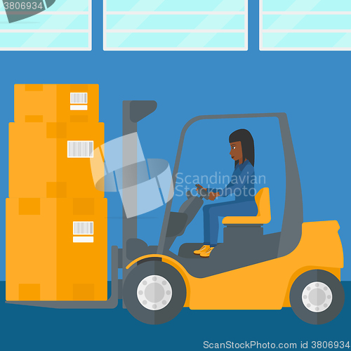 Image of Warehouse worker moving load by forklift truck.