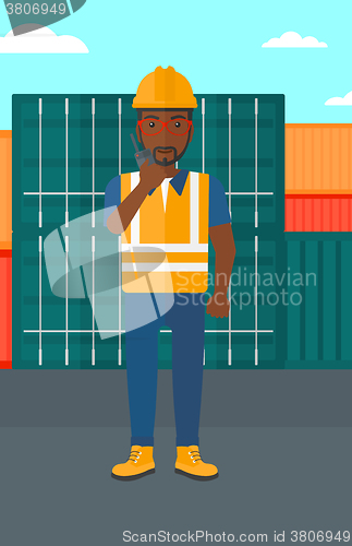 Image of Stevedore standing on cargo containers background.