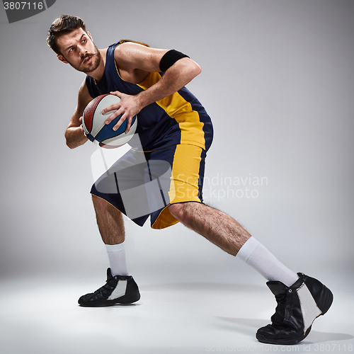 Image of Full length portrait of a basketball player with ball 