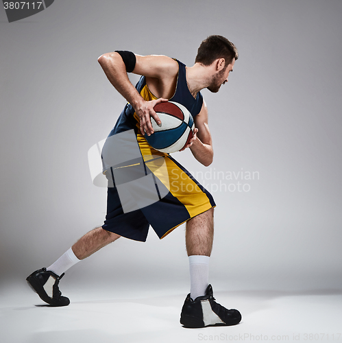 Image of Full length portrait of a basketball player with ball 