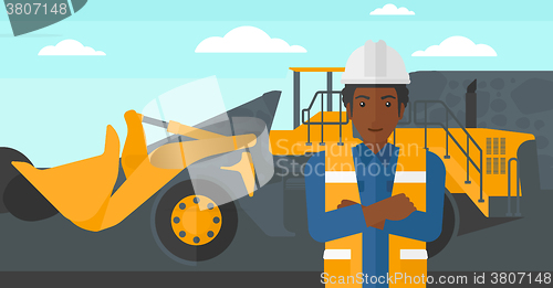 Image of Miner with mining equipment on background.