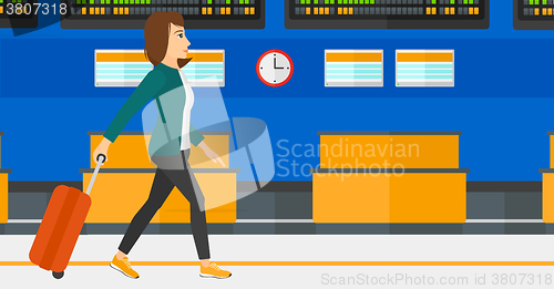 Image of Woman walking with suitcase.