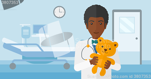 Image of Pediatrician holding teddy bear.