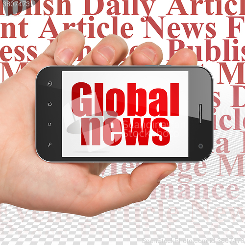 Image of News concept: Hand Holding Smartphone with Global News on display