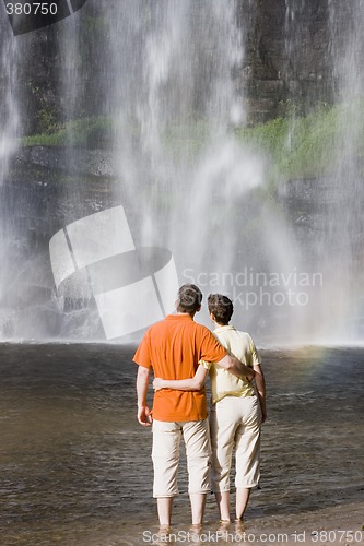 Image of Couple contemplating a waterfall