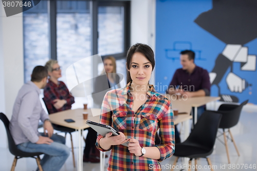 Image of portrait of young business woman at office with team in backgrou