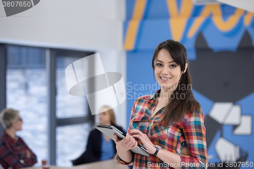 Image of portrait of young business woman at office with team in backgrou