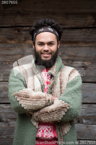 Image of portrait of young hipster in front of wooden house