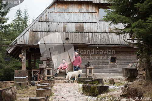 Image of frineds together in front of old wooden house