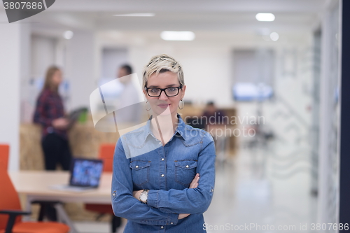 Image of portrait of young business woman at office with team in backgrou