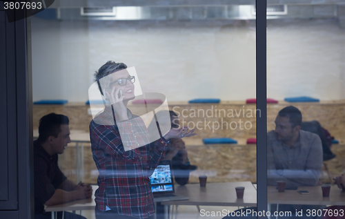 Image of business woman in meeting room  speaking by cell phone