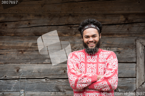 Image of portrait of young hipster in front of wooden house