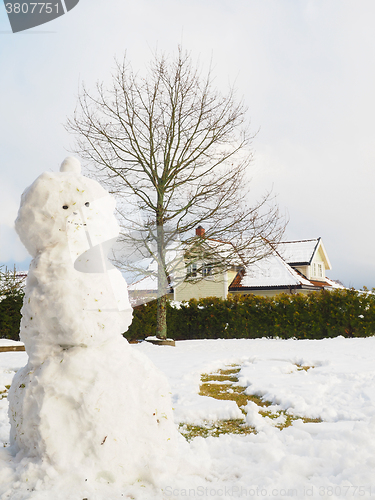 Image of Snowman in garden half done, without scarf, hat and carrot in fr