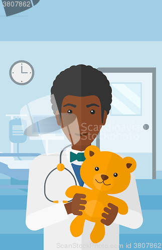 Image of Pediatrician holding teddy bear.