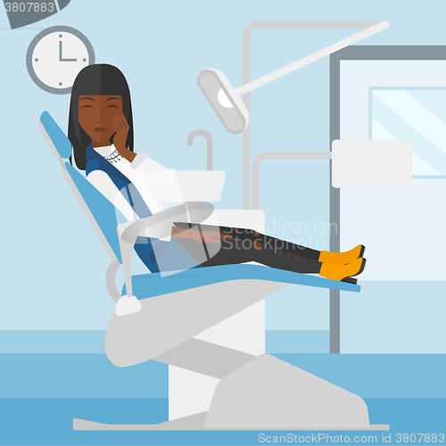 Image of Woman suffering in dental chair.