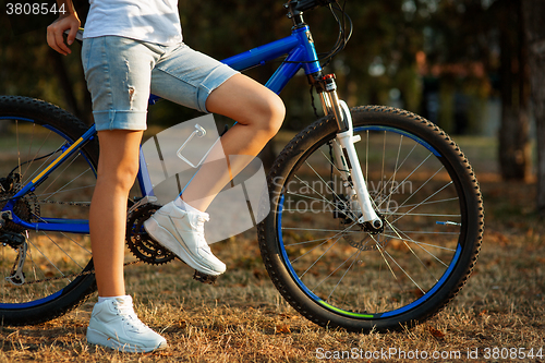 Image of teenage girl with bike in the city park