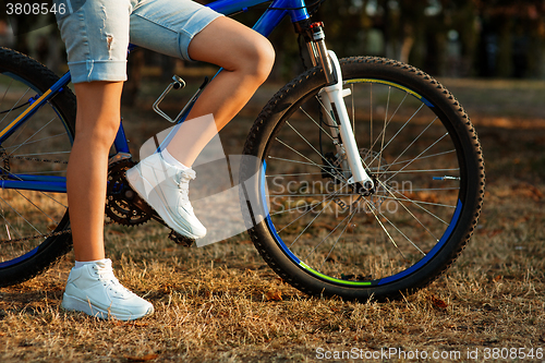 Image of teenage girl with bike in the city park